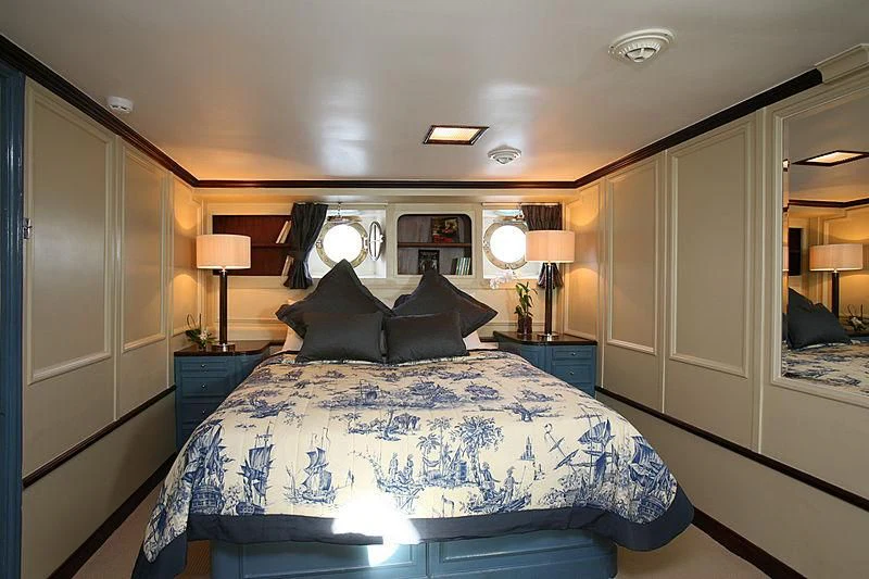 a bed with a blue sheet aboard CALISTO Yacht for Sale