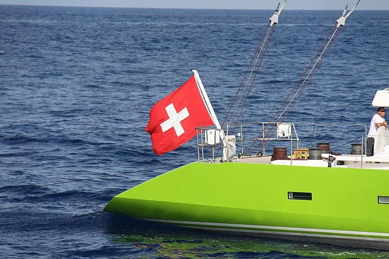 a green boat with a flag on it aboard INOUI Yacht for Sale