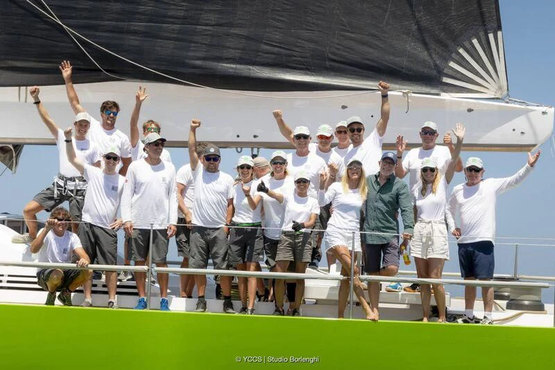 a group of people posing for a photo on a tennis court aboard INOUI Yacht for Sale