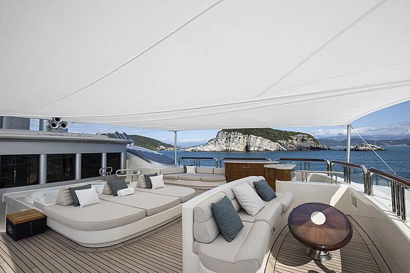 a large white lounge chair on a deck overlooking a large body of water aboard FIREBIRD Yacht for Charter