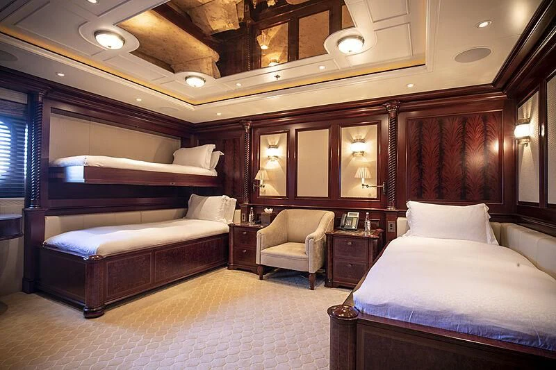 a room with a bed and a chair aboard FIREBIRD Yacht for Charter
