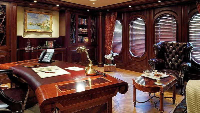 a room with a table chairs and a lamp aboard FIREBIRD Yacht for Charter