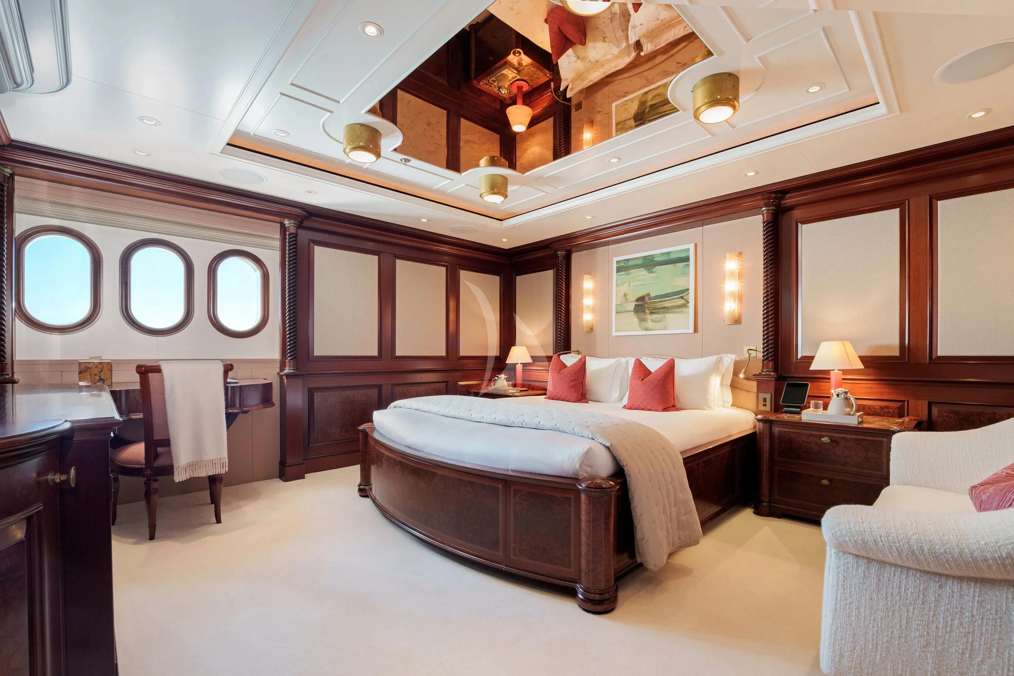 a large bedroom with a bed and a chair aboard FIREBIRD Yacht for Charter