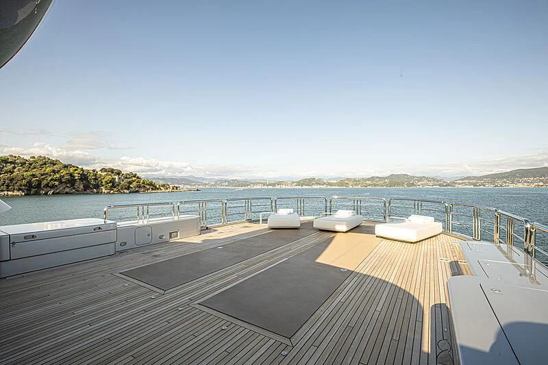a deck with a view of the ocean and mountains in the background aboard FIREBIRD Yacht for Charter
