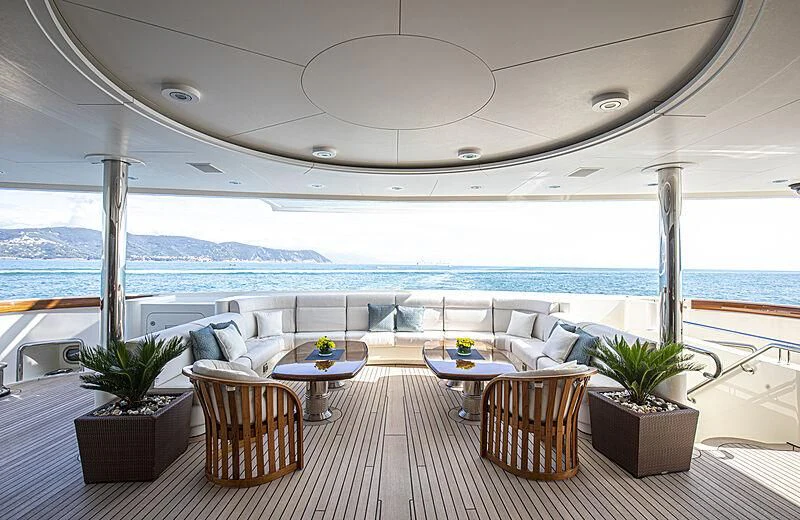 a room with a table chairs and plants on the patio aboard FIREBIRD Yacht for Charter