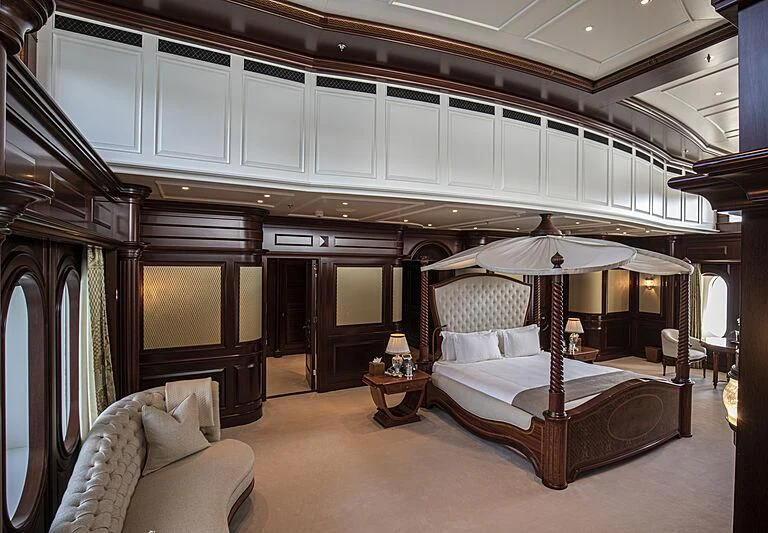 a bedroom with a bed and a table aboard FIREBIRD Yacht for Charter