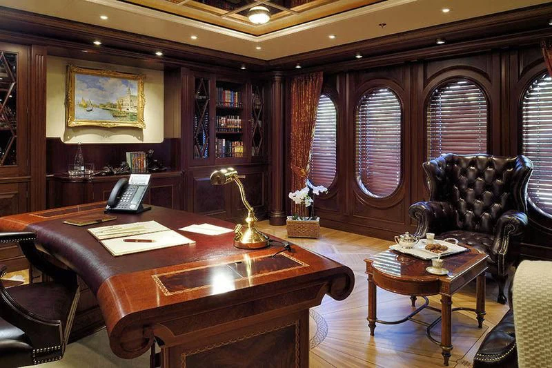 a room with a table chairs and a lamp aboard FIREBIRD Yacht for Charter