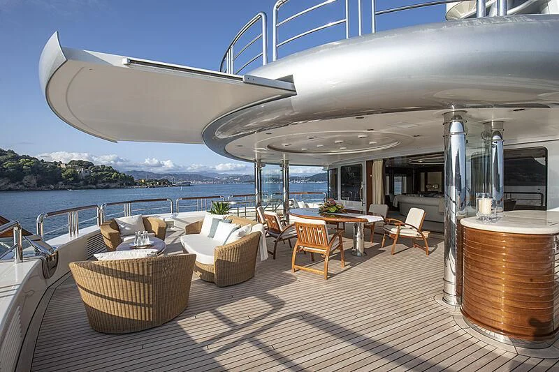 a deck with a table and chairs aboard FIREBIRD Yacht for Charter