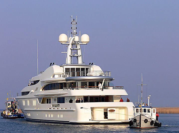 a large white boat with a couple of smaller boats in the water aboard FIREBIRD Yacht for Charter