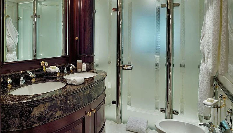 a bathroom with a countertop sink and a shower unit aboard FIREBIRD Yacht for Charter
