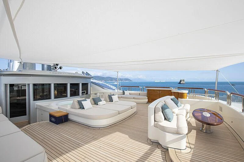 a large white lounge chair on a deck overlooking a large body of water aboard FIREBIRD Yacht for Charter