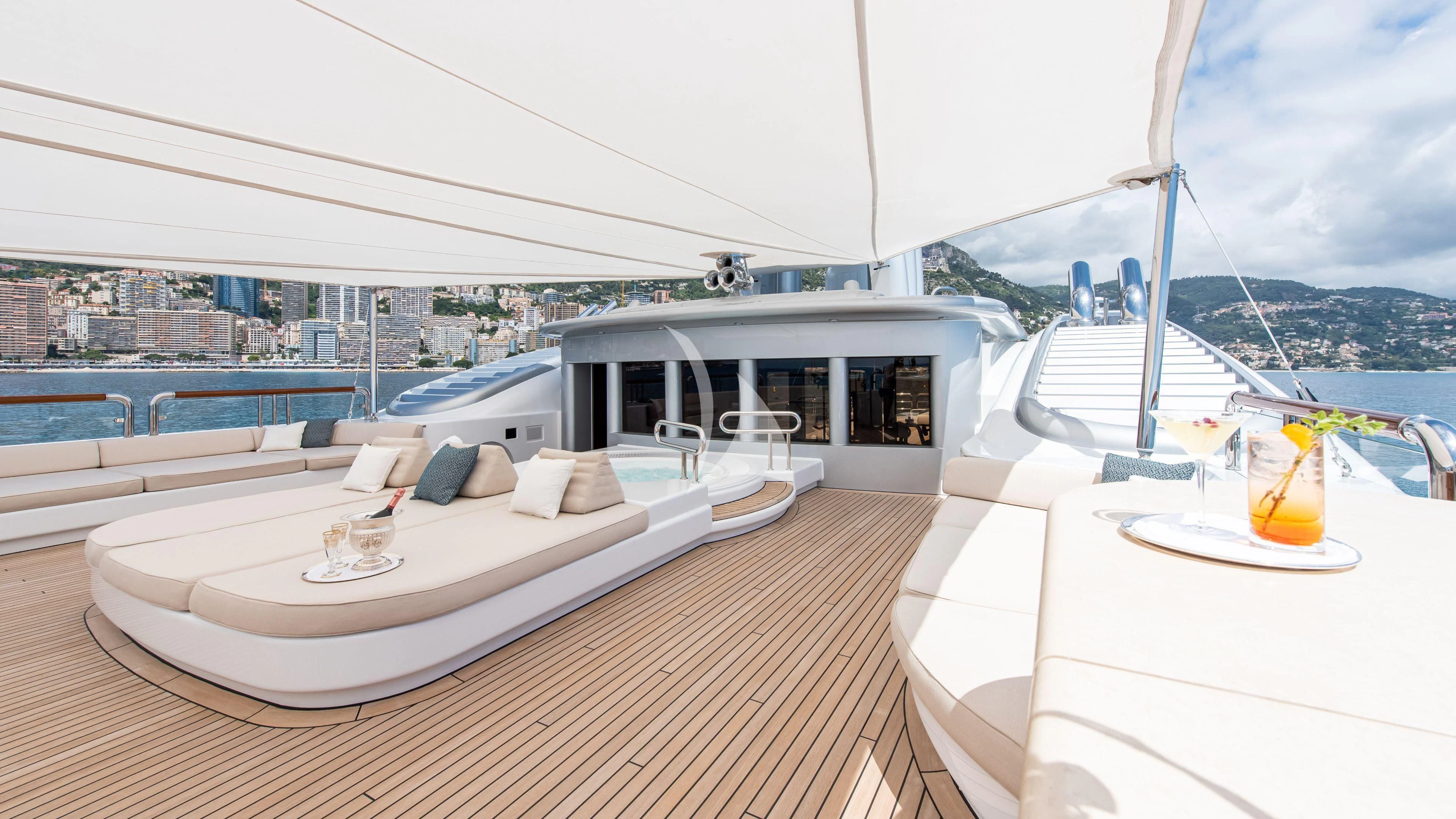 a room with a bed and a table and a glass of juice aboard FIREBIRD Yacht for Charter