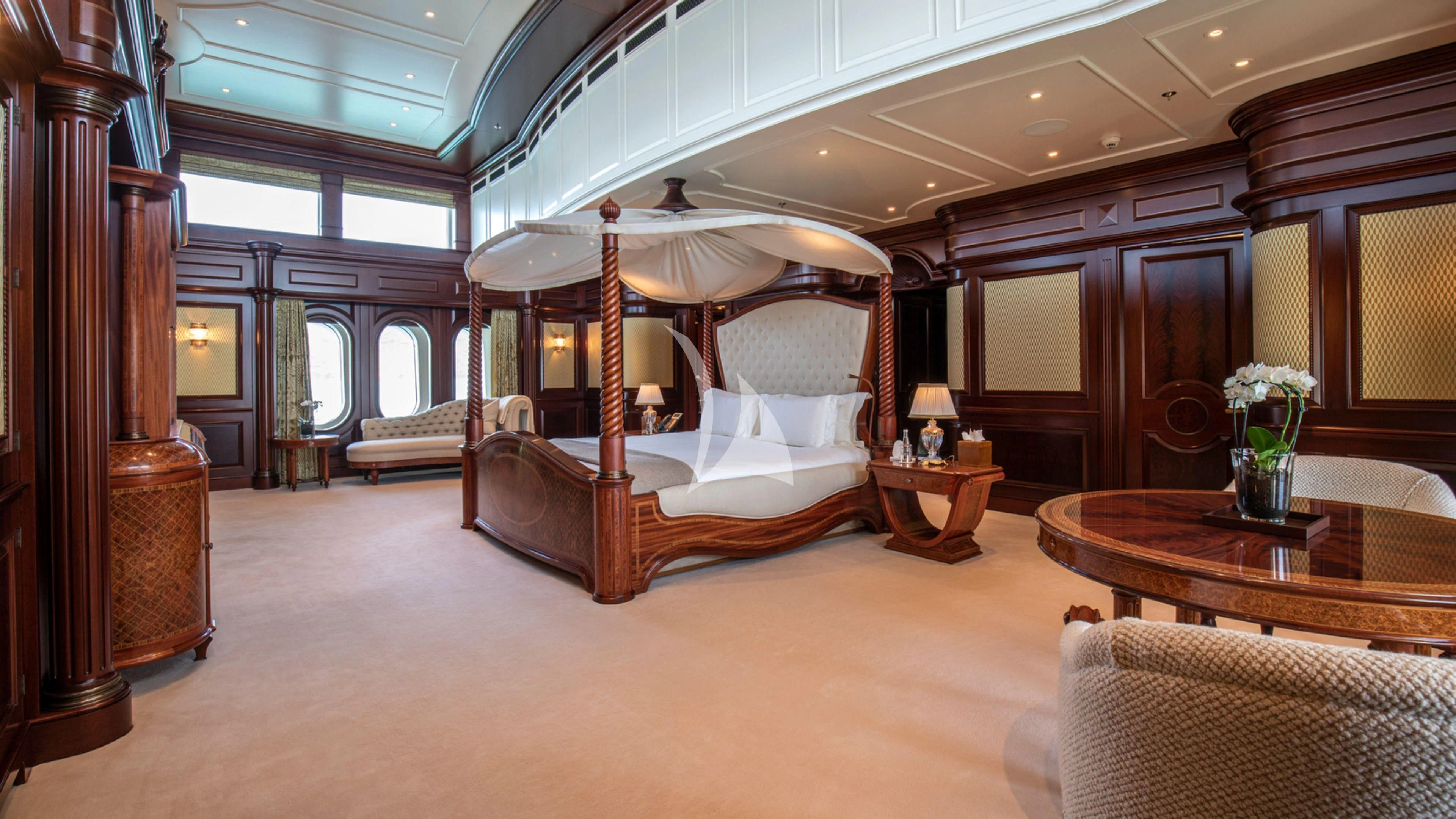 a large bedroom with a bed and a table aboard FIREBIRD Yacht for Charter