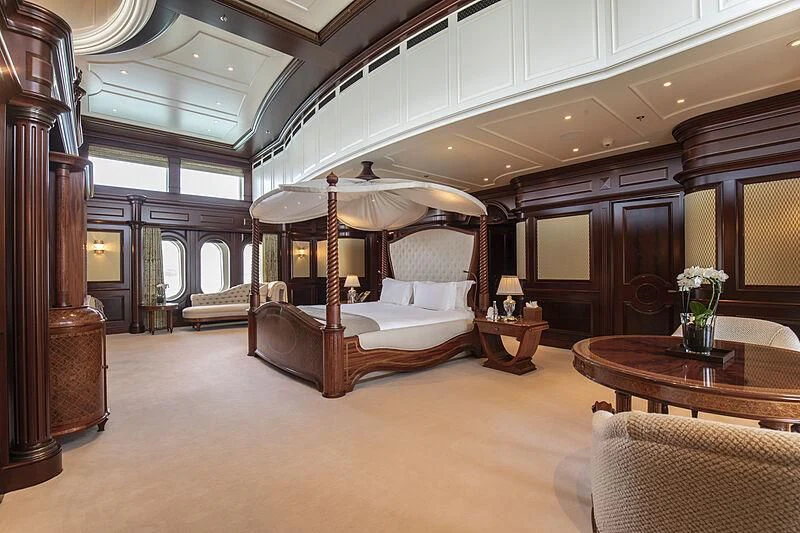 a large bedroom with a bed and a table aboard FIREBIRD Yacht for Charter