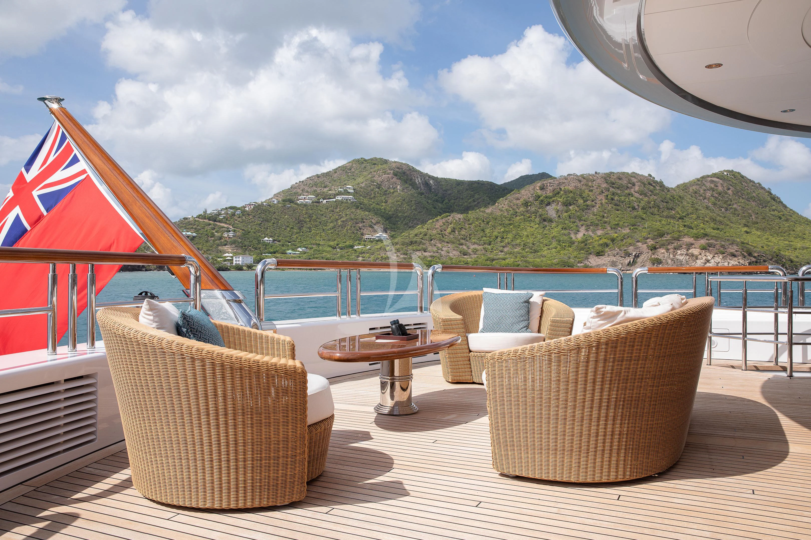 a table and chairs on a deck overlooking a body of water aboard FIREBIRD Yacht for Charter
