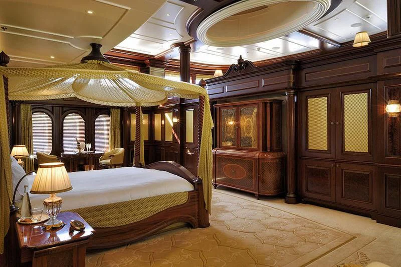 a bedroom with a bed and a table aboard FIREBIRD Yacht for Charter