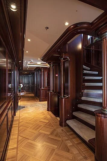 a hallway with a wood floor and a staircase aboard FIREBIRD Yacht for Charter