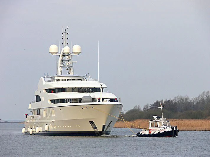 a large white boat with a smaller boat on the water aboard FIREBIRD Yacht for Charter