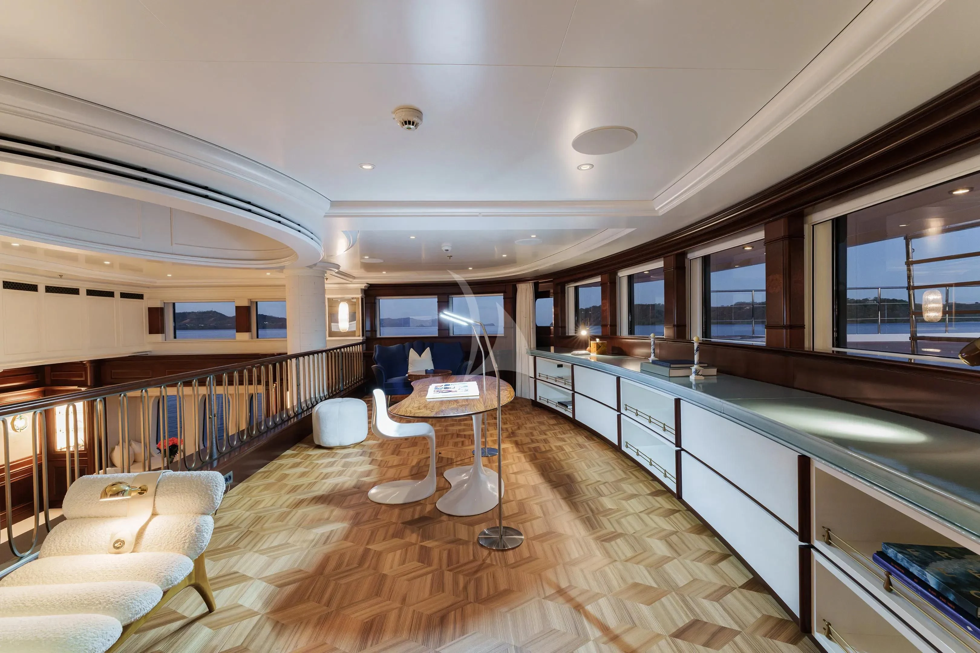 a large room with a wood floor and a table and chairs aboard FIREBIRD Yacht for Charter
