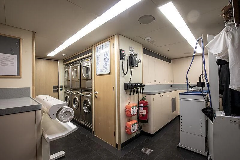 a room with a washing machine and dryer aboard FIREBIRD Yacht for Charter