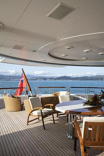 a patio with tables and chairs and umbrellas aboard FIREBIRD Yacht for Charter