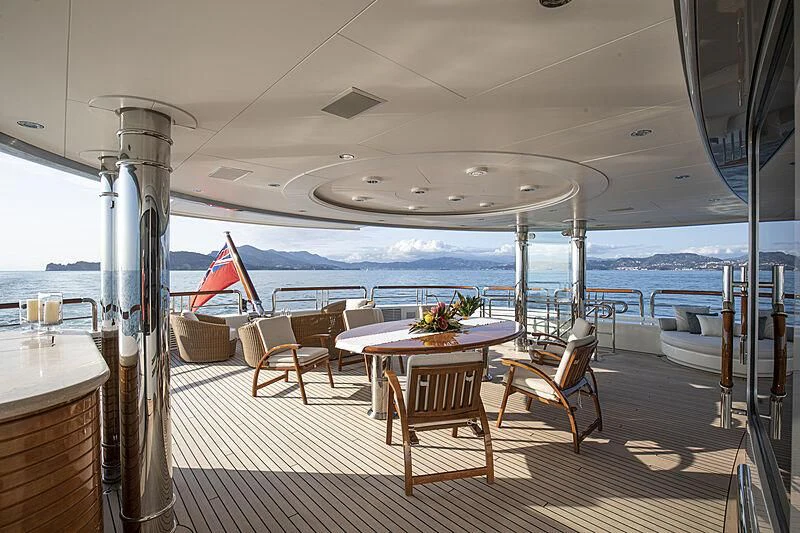 a room with a table chairs and a large body of water aboard FIREBIRD Yacht for Charter