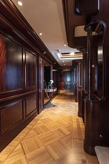a large wood hallway with a large mirror and a table and chairs aboard FIREBIRD Yacht for Charter