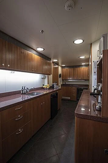 a kitchen with wooden cabinets aboard FIREBIRD Yacht for Charter