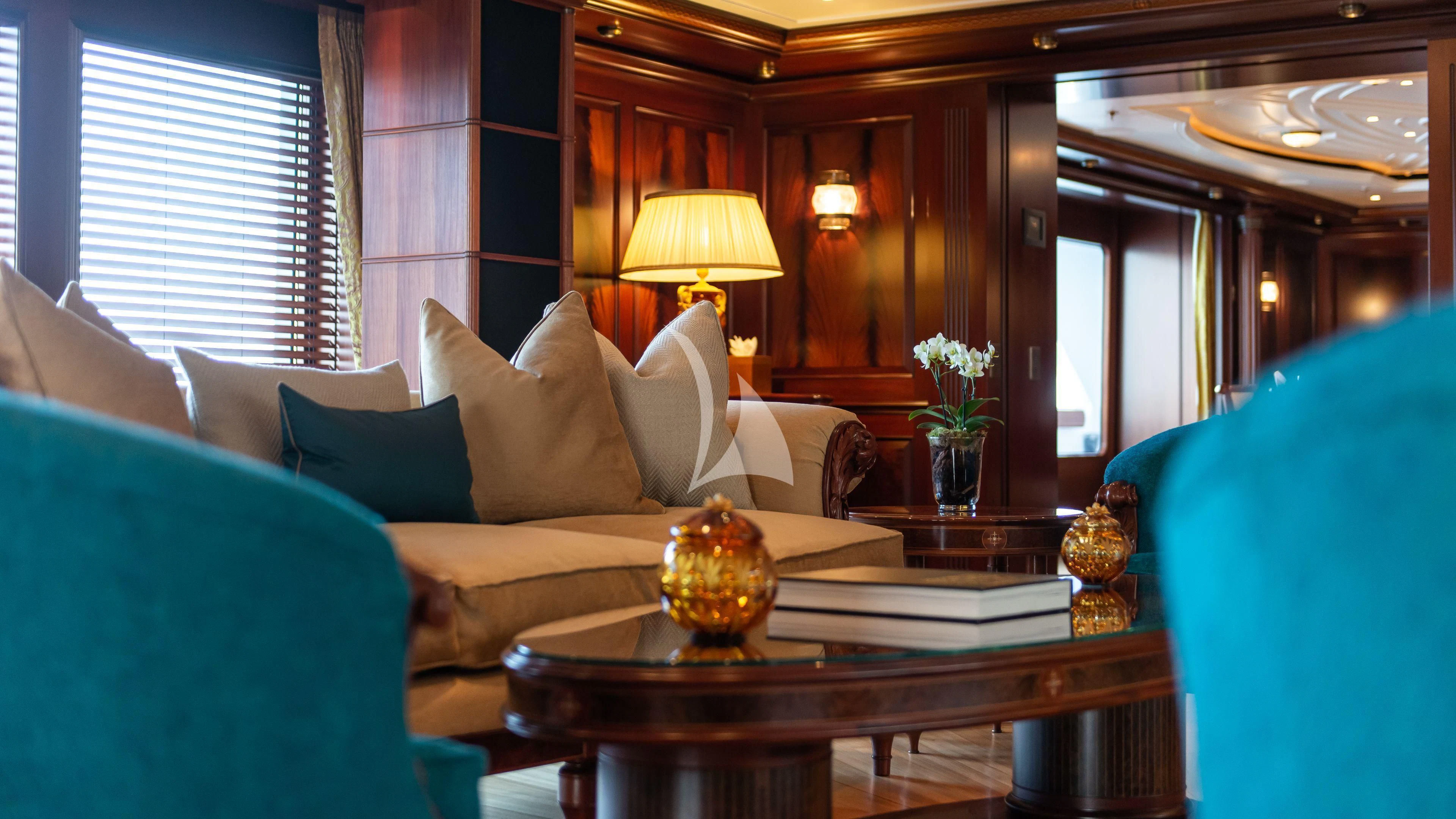 a living room with a blue couch and a coffee table aboard FIREBIRD Yacht for Charter