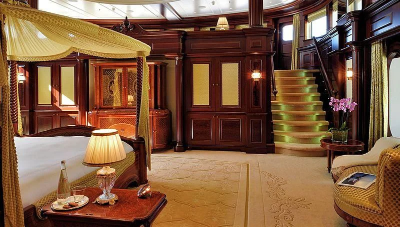 a room with a staircase and a table and chairs aboard FIREBIRD Yacht for Charter