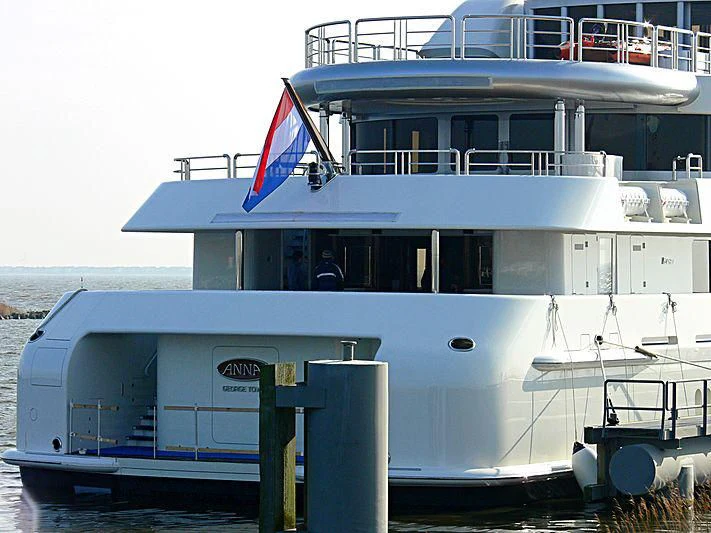 a large boat with a flag on the front aboard FIREBIRD Yacht for Charter