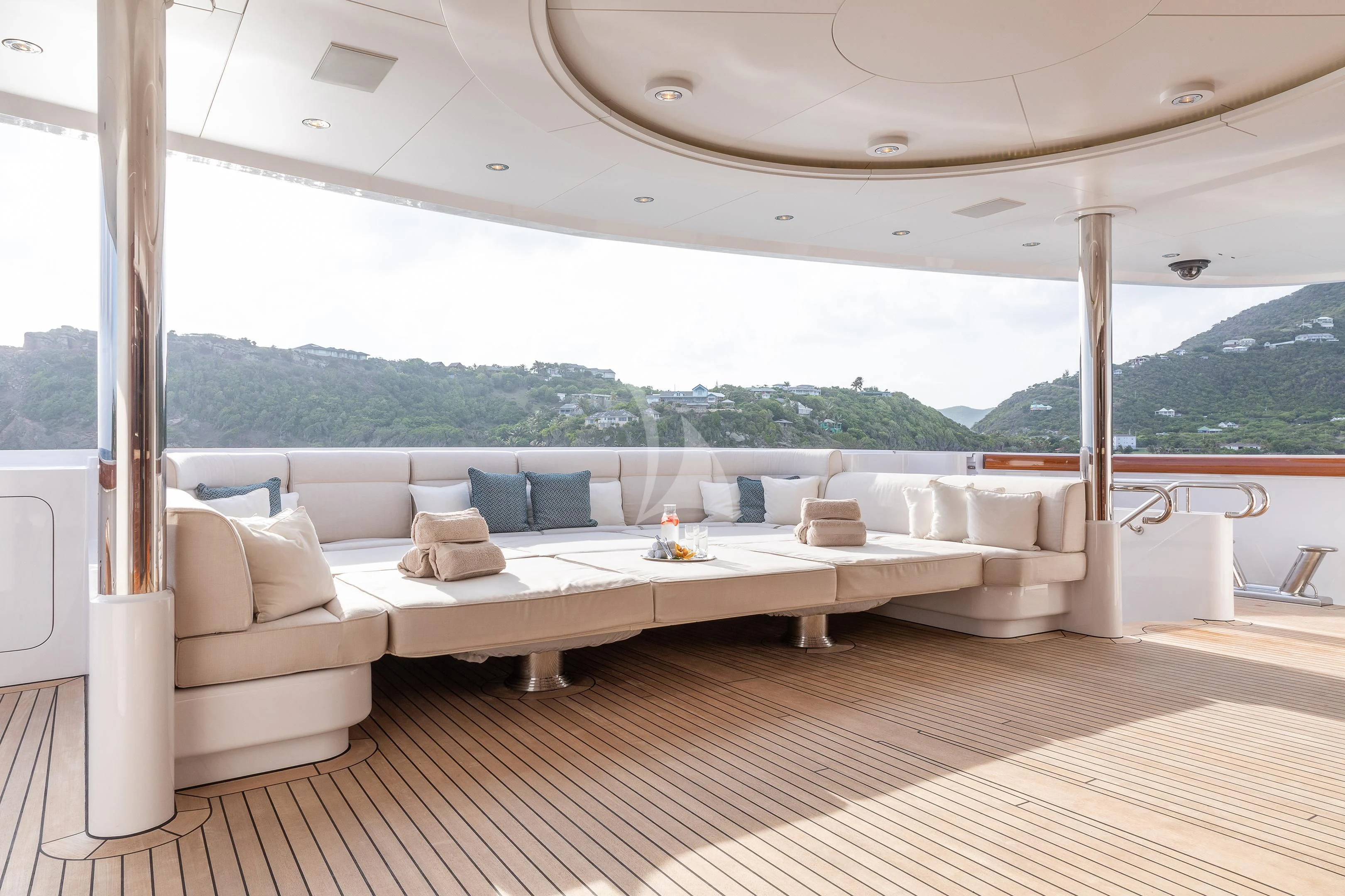 a large white lounge chair on a deck with a large window overlooking a lake aboard FIREBIRD Yacht for Charter