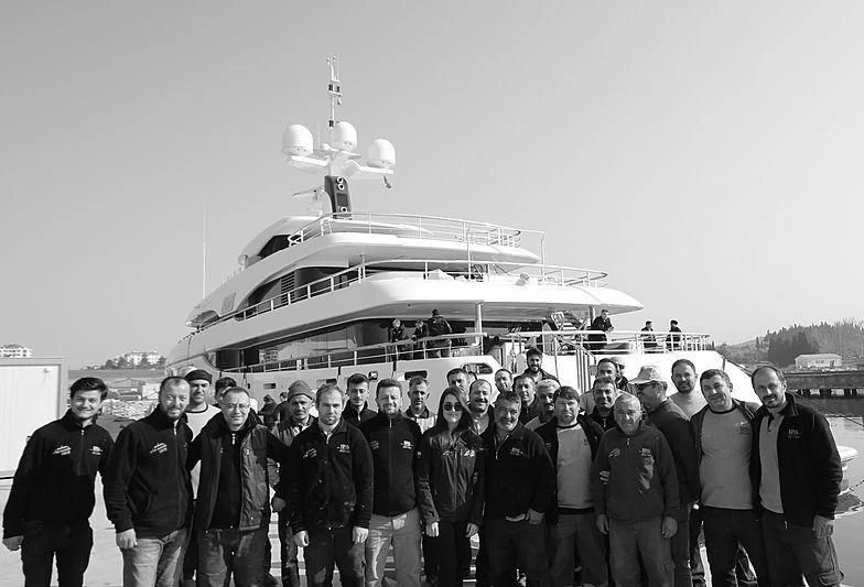 a group of people posing for a photo in front of a ship aboard RAHIL Yacht for Sale