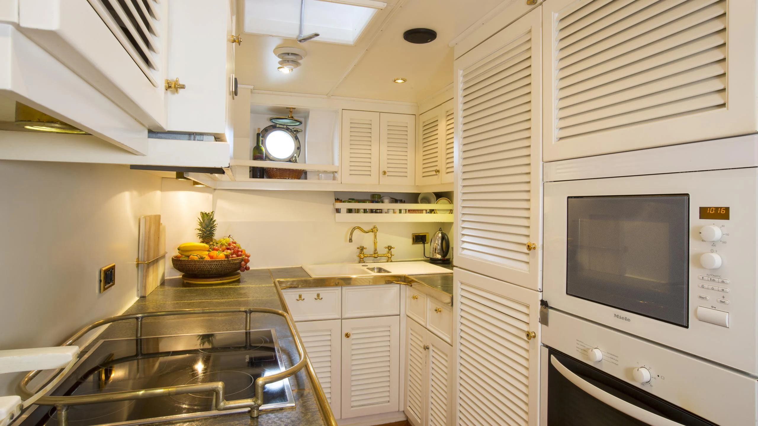 a kitchen with white cabinets aboard ASCHANTI IV OF VEGESACK Yacht for Sale