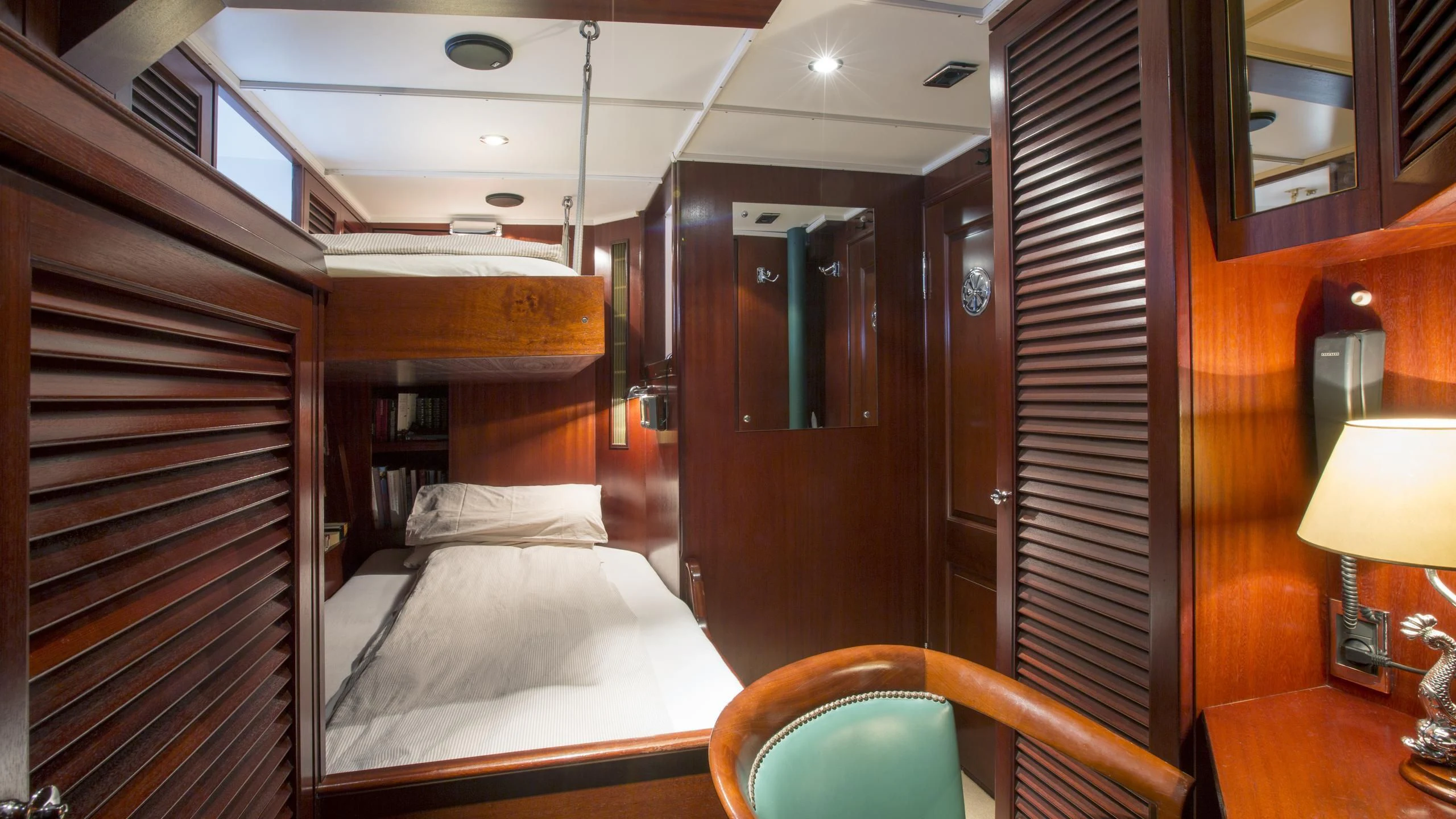 a room with a bed and a lamp aboard ASCHANTI IV OF VEGESACK Yacht for Sale