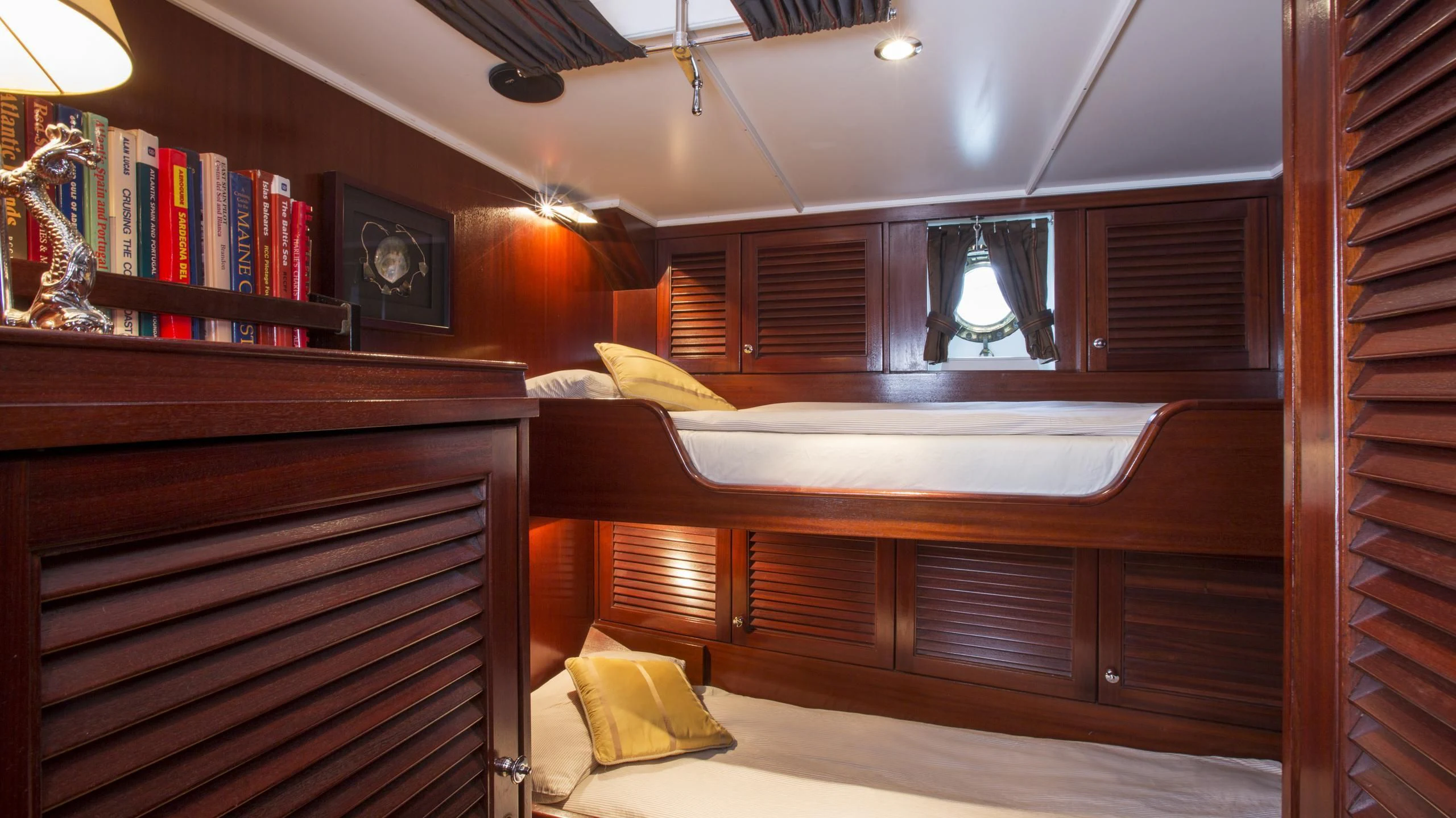a room with a bed and a desk aboard ASCHANTI IV OF VEGESACK Yacht for Sale
