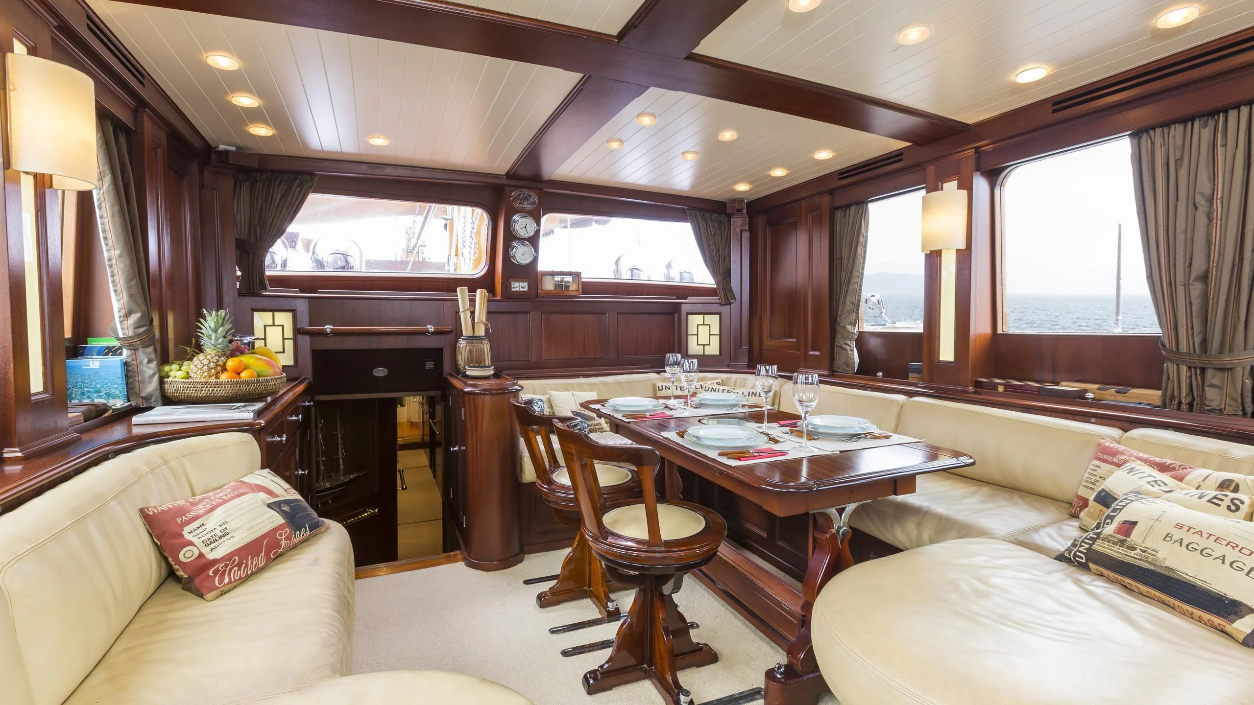 a living room with a table and couches aboard ASCHANTI IV OF VEGESACK Yacht for Sale