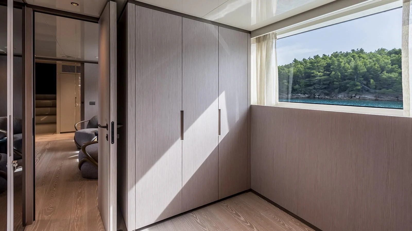 a room with a window and a chair aboard EROS Yacht for Sale