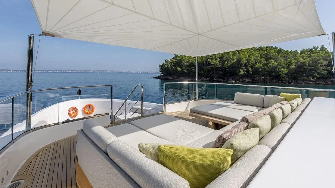 a lounge chair on a deck overlooking a body of water aboard EROS Yacht for Sale