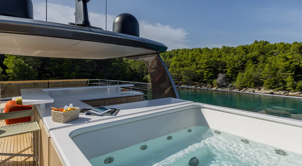 a pool with a large umbrella aboard EROS Yacht for Sale