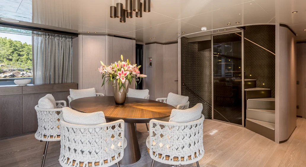 a living room with a table and chairs aboard EROS Yacht for Sale