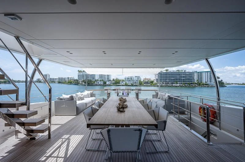 a table and chairs on a deck aboard EROS Yacht for Sale