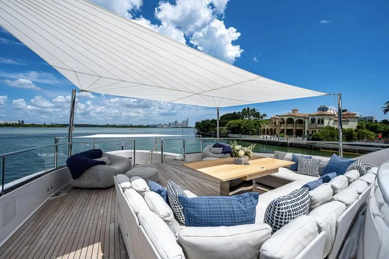 a deck with chairs and a table on it aboard EROS Yacht for Sale