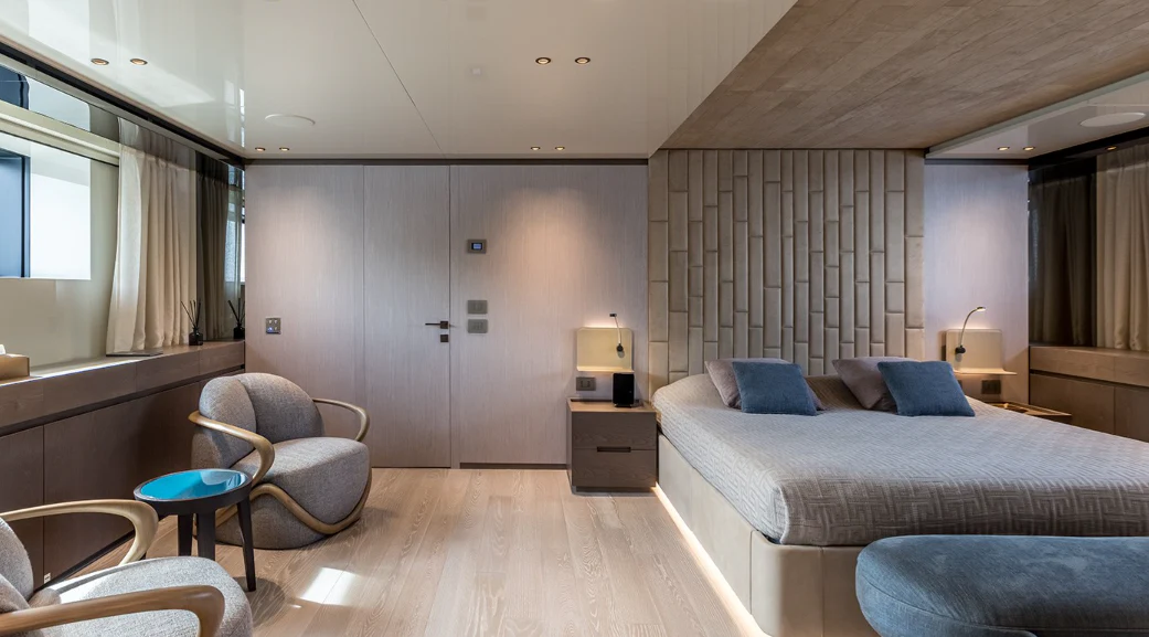 a bedroom with a bed and a chair aboard EROS Yacht for Sale