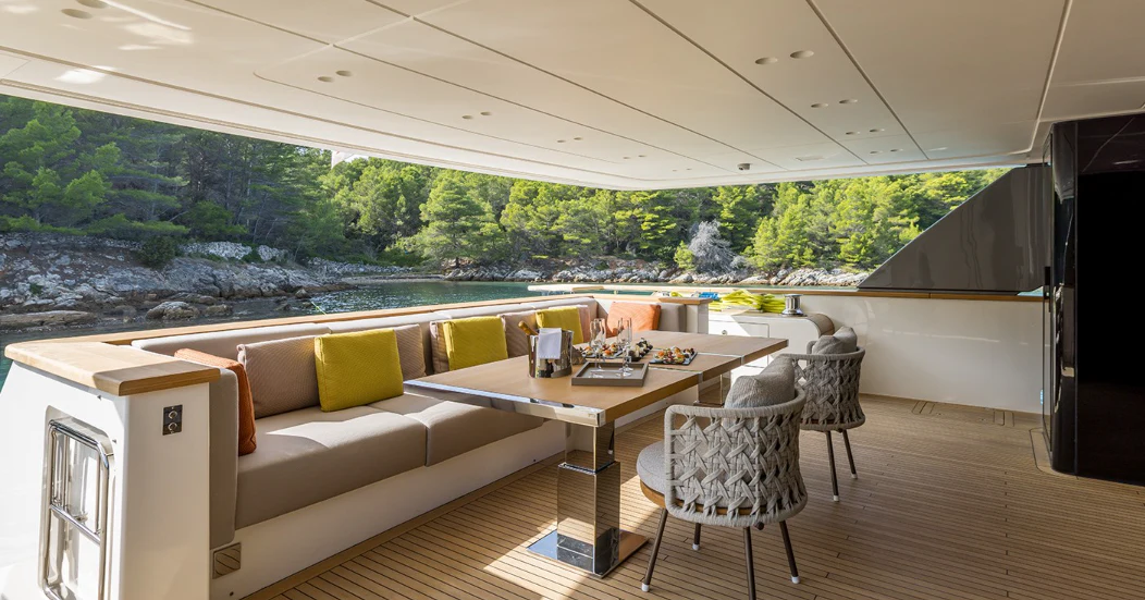 a room with a couch and a table and chairs aboard EROS Yacht for Sale