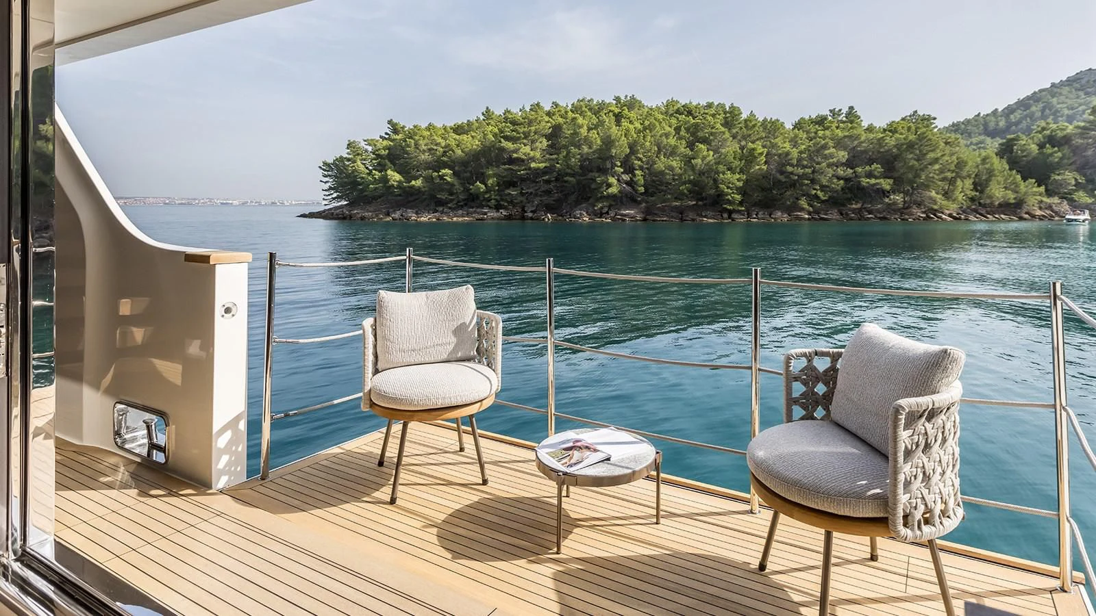 a couple chairs on a deck overlooking a body of water aboard EROS Yacht for Sale
