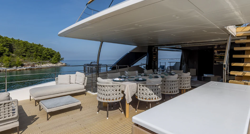 a room with a pool and a deck with chairs and tables aboard EROS Yacht for Sale