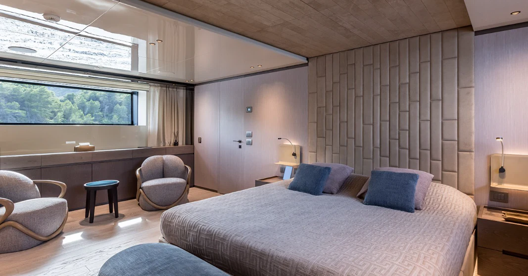 a bedroom with a bed and a desk aboard EROS Yacht for Sale