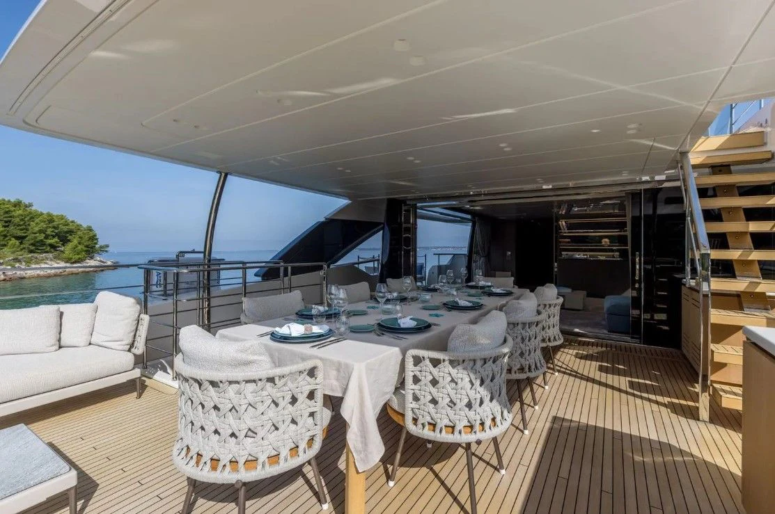 a large room with a table and chairs and a large window aboard EROS Yacht for Sale