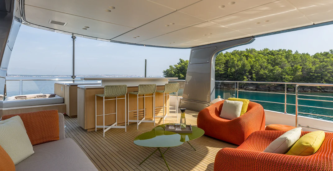 a room with a table chairs and a couch aboard EROS Yacht for Sale